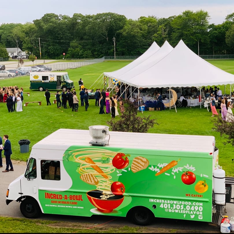 Incred-A-Bowl food truck at an outdoor event with a large white tent and many people.
