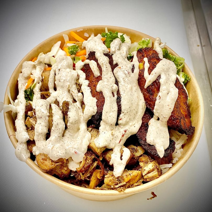 A healthy Incred-A-Bowl with plantains, rice, vegetables, and a creamy dressing.