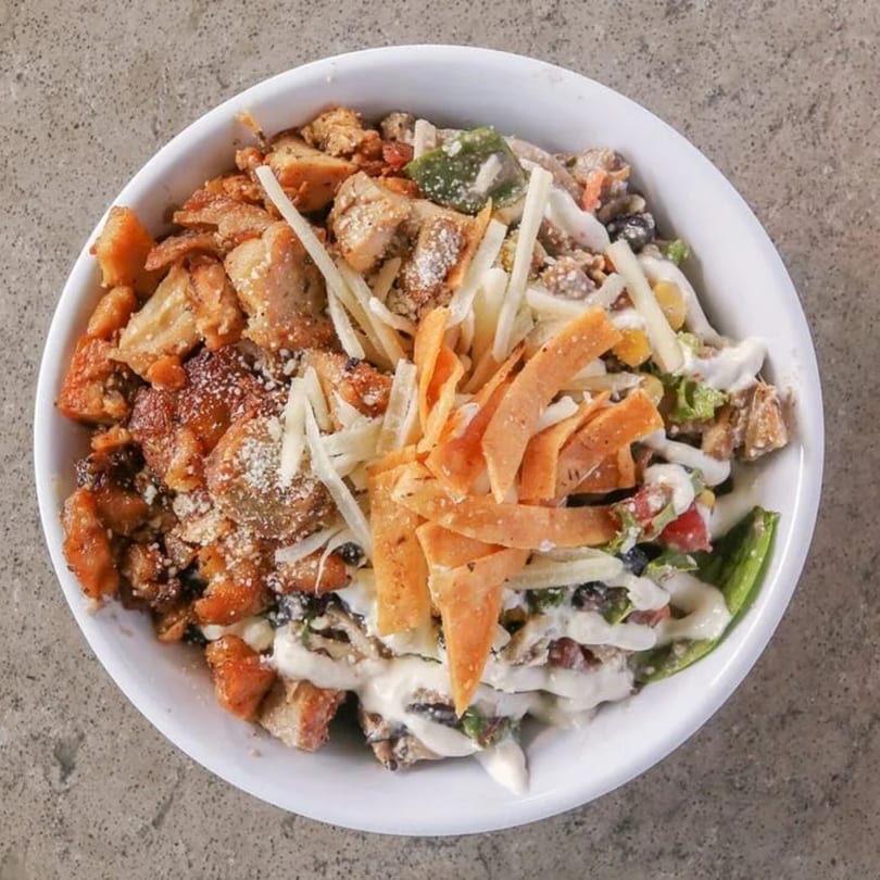 Overhead view of a healthy Incred-A-Bowl with chicken, cheese, and tortilla strips.